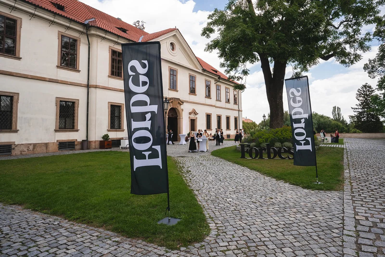Forbes vlajky a prelatura Břevnovského kláštera při příchodu hostů